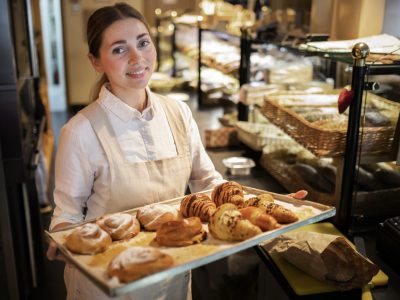 medium-shot-smiley-woman-holding-tray